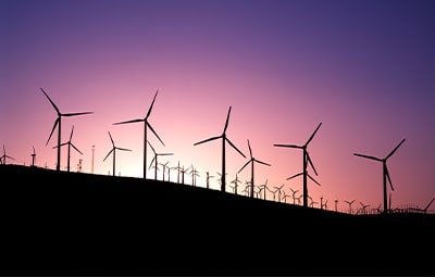 Wind turbines on a hill at sunset